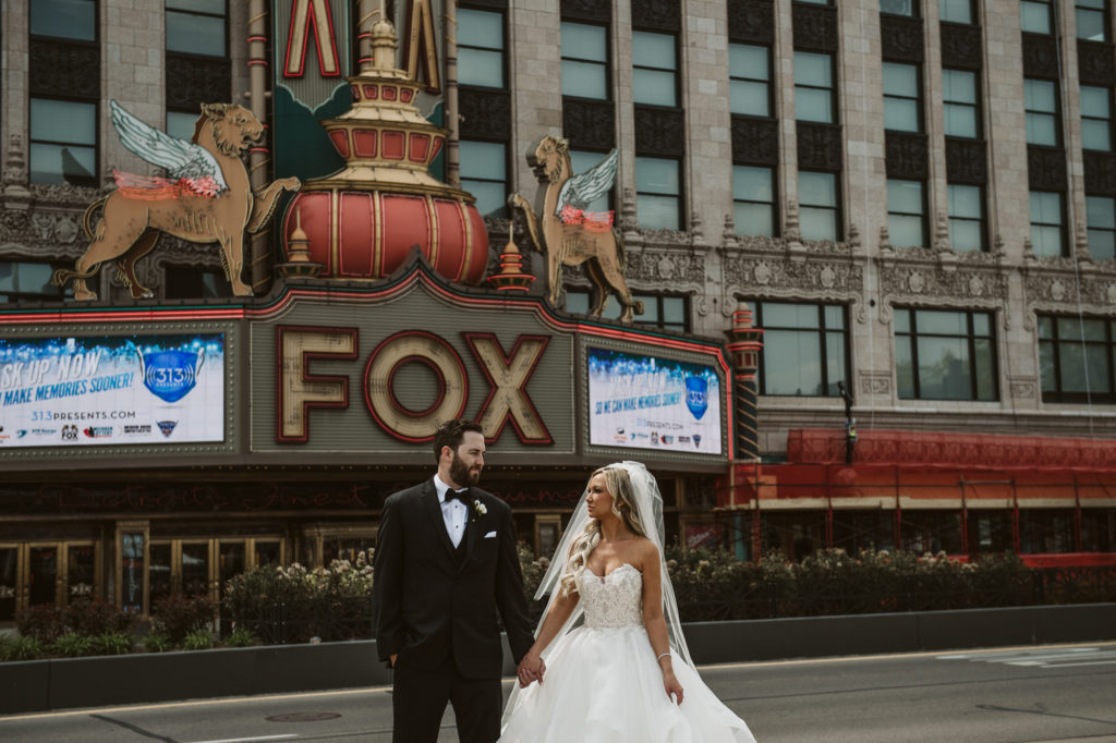 Bride and groom look at each other softly with Fox Theater behind them