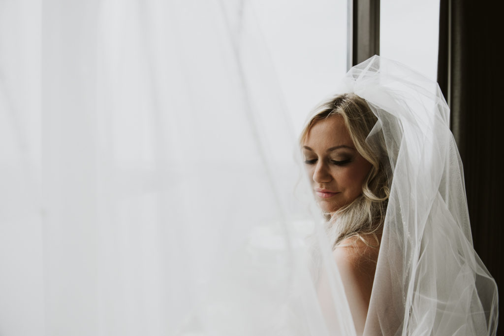 Bride looking down with veil spread all around her